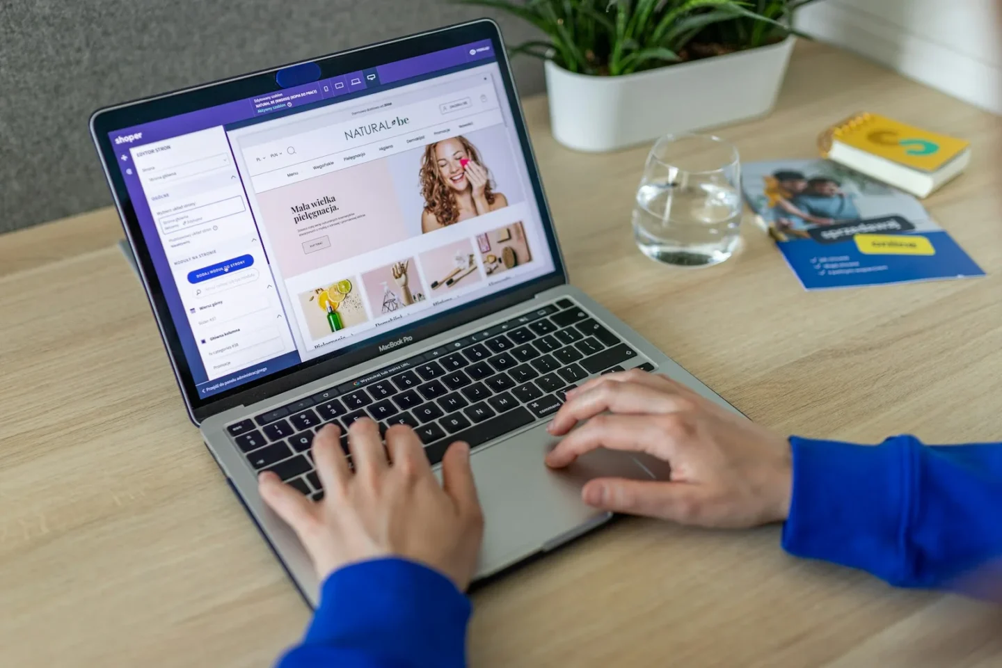 Händer på en laptop där en webbutik med produktbilder redigeras i butikens adminpanel